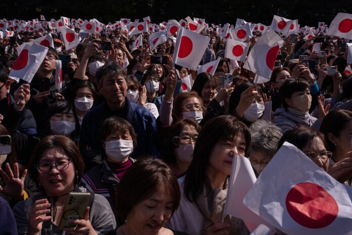Pôrodnosť v Japonsku 10 rokov po sebe klesá, premiérka to označila za „tichý núdzový stav“. Na snímke priaznivci mávajú vlajkami japonskému cisárovi Naruhitovi a ďalším členom cisárskej rodiny pri príležitosti cisárových 66. narodenín. Foto - TASR/AP